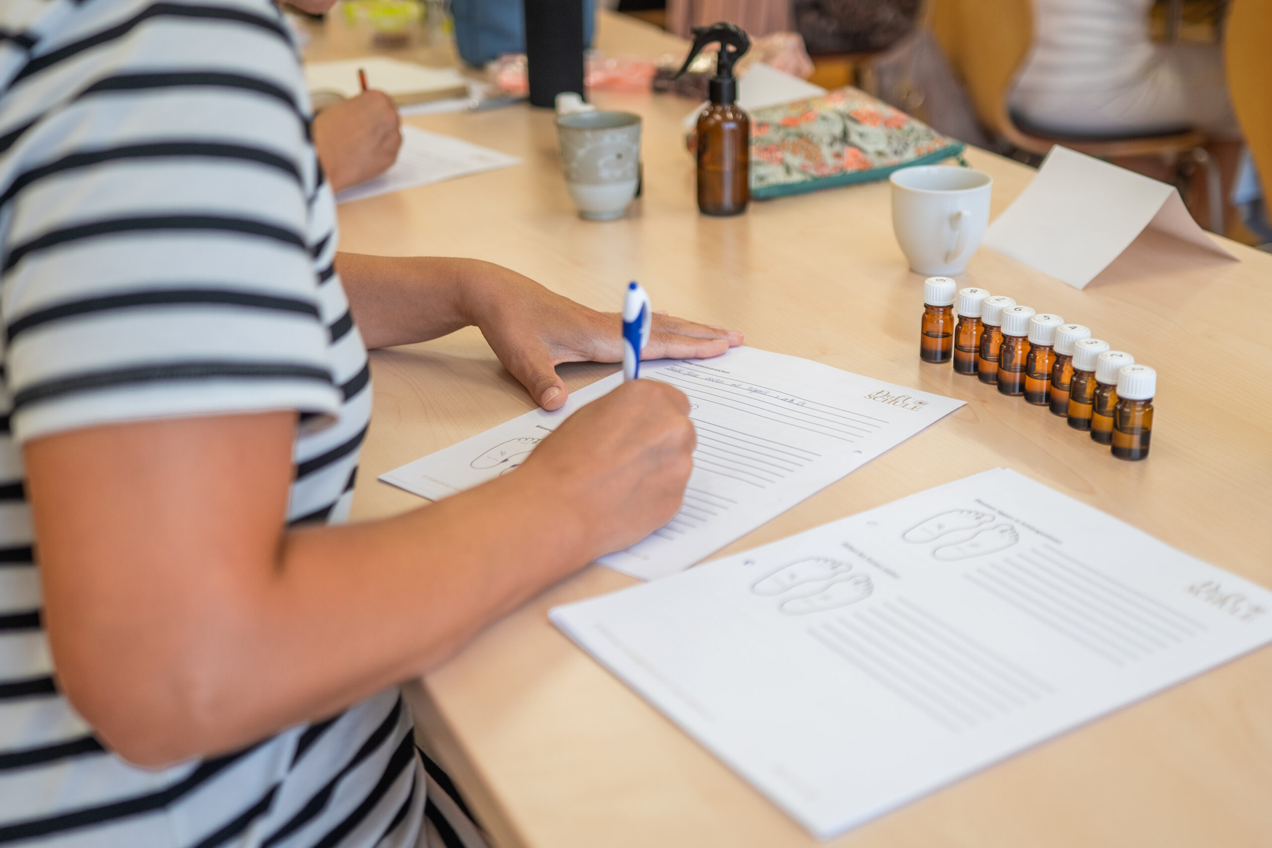 Teilnehmerinnen der Organsprache-Ausbildung beim Lernen mit Kursunterlagen und Austausch in der Community